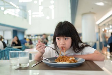 Çocuk yemek yiyor, eğleniyor, kahvaltı yapıyor.