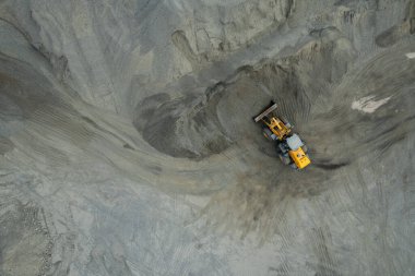 Kum yükleyicileri çöp kamyonlarına taş topluyor.