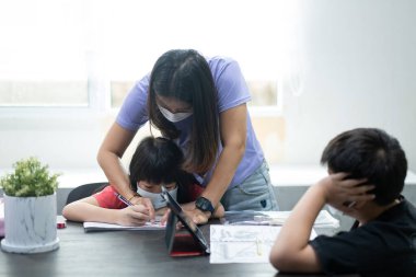 Anne ile ödev yapan çocuk, kağıt yazan çocuk, eğitim konsepti, okula dönüş.