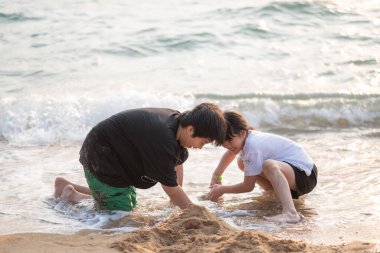 Çocuklar kumsalda oynuyorlar.