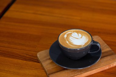 Tahta masada sıcak latte sanat kahvesi, rahatla Tim.