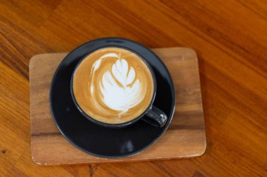 Tahta masada sıcak latte sanat kahvesi, rahatla Tim.