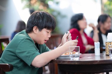 Çocuk yemek yiyor, eğleniyor, kahvaltı yapıyor.