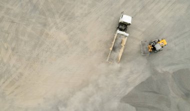 Kum yükleyicileri çöp kamyonlarına taş topluyor.