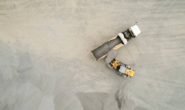 Kum yükleyicileri çöp kamyonlarına taş topluyor.