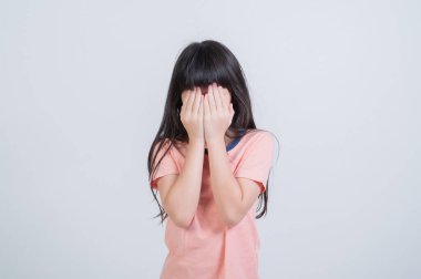 Kız elleriyle gözlerini kapatıyor.