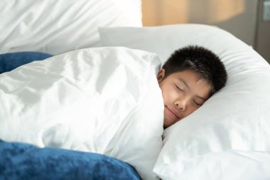 Asyalı çocuk yatakta uyuyor, çocuk hasta, çocuk kızak.