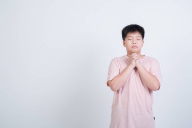 Beyaz arka planda dua eden çocuk