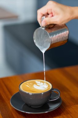 Kapalı el sıcak latte sanat kahvesi yapıyor.