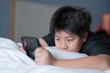 Akıllı telefon oynayan öğrenci, araba izleyen çocuklar.