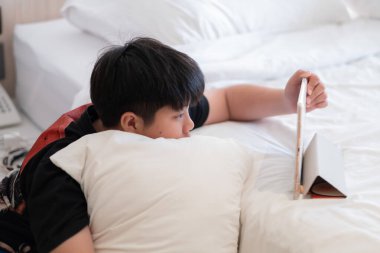 Asyalı Çinli çocuk akıllı telefon oynuyor, çocuk telefon kullanıyor ve oyun oynuyor, bağımlı oyun ve araba kullanıyor.