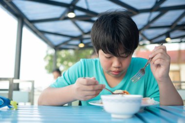 Asyalı çocuk yemek yiyor, aç çocuk.