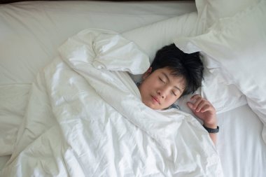 Asyalı çocuk yatakta uyuyor, çocuk hasta, çocuk kızak.