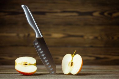 Bıçak. Paslanmaz çelik bıçak, elma. Şef ya da kasap bıçağı. Mutfakta profesyonel ekipman var. Dilimlenmiş meyve, sebze ve et için bıçak. Bir parça mutfak gereçleri. Yemek takımı seti. Ahşap masa arkaplanı.