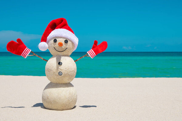 Снеговик. Сэнди Снеговик на пляже. Рождественский снеговик в красной шляпе Санта-Клауса и варежках. Смайли Сноу. Майами Бич Флорида. Зимние каникулы. Празднование Нового года. Рождественские открытки. Путешествия