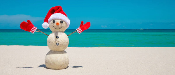 Snowman. Sandy Snowman on the beach. Christmas snowman with red Santa Claus hat and mittens. Smiley Snow man. Miami Beach Florida. Winter Holidays. Celebration Happy New Year. Xmas postcards. Travels