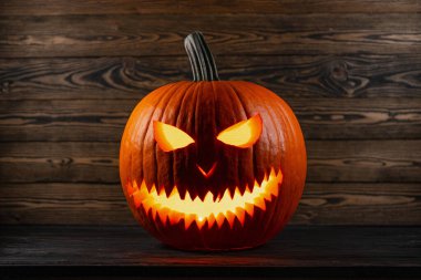 Mutlu Cadılar Bayramı. Jack o Lantern.Cadılar Bayramı partisinde balkabağı. Gülümseyen Jack-o 'Lantern suratı. Mum Işıkları. Ev için dekorasyon fikri, cadılar bayramında ev. Sonbahar, sonbahar mevsimi. Tahta çit.