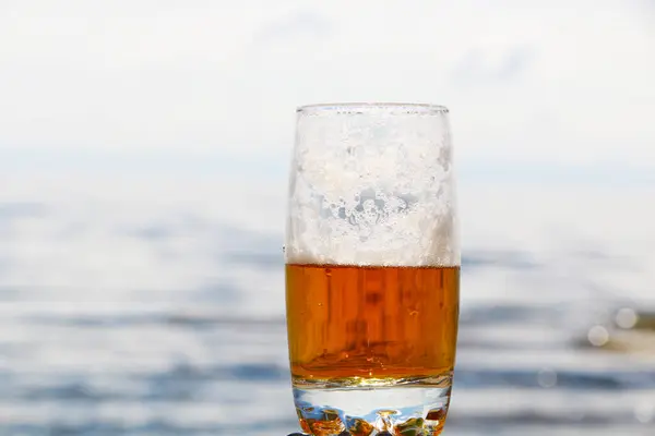 Золотой Пенный Напиток Прозрачном Стакане Фоне Моря Пляжа Пиво Пеной — стоковое фото