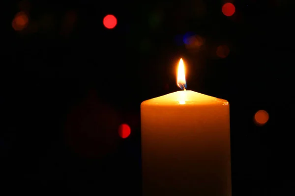 圣诞蜡烛在一棵美丽的圣诞树的后面 点缀着球的云杉树背景下的新年烛光 免版税图库照片