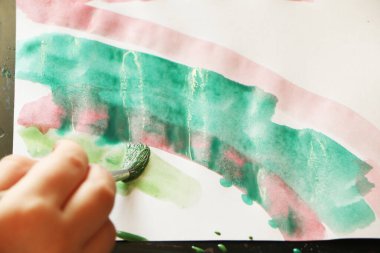 Bir çocuk suluboya boya ile resim yapar. Okulda resim dersi sırasında..