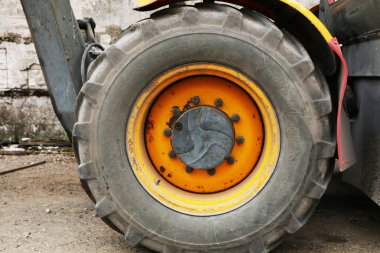 Bir traktör veya yükleyicinin çalışan tekerleklerine yakın çekim. Hasat sırasında traktör.
