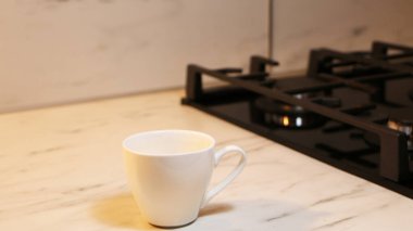 Erkek eller mutfakta kahve dolduruyor. Adam mutfakta bir pastanın arka fonuna kahve döküyor..