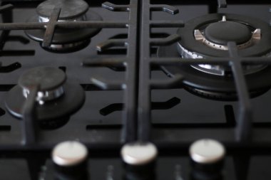 Siyah seramik gaz sobası. Yakın plan. Çalışan modern bir gaz ocağında mavi alev..