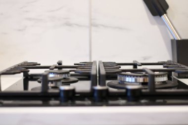 Bir adamın eli mutfak sobasının gazını yakıyor. Bir aşçı yemek pişirmek için gaz sobasını yakar..