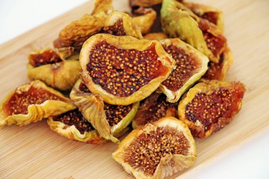 Cut dried figs on wooden background close-up.