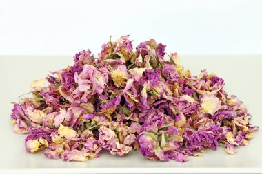 Bej bir tepside bir yığın kuru gül yaprağı. Stüdyo çekimi.