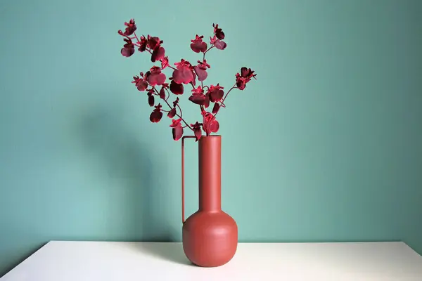 Branche Fleurie Dans Vase Céramique Moderne Sur Une Table Blanche Image En Vente