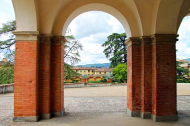 View of the summer garden of the Villa Medici through the arch of the gallery close-up. Poggio a Caiano in Tuscany, Italy. clipart