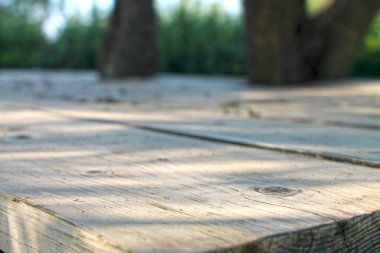 Yaz bahçesindeki ahşap tahta masanın bulanık arka planı .