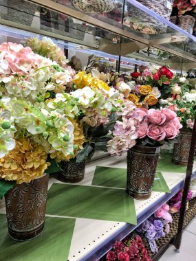 26.12.2022, Ukrayna, Harkiv, çiçekçi dükkanı. Güzel suni çiçekli raflar ve sepetlerde buketler.