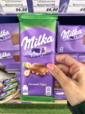 28.04.2023, Ukrayna, Harkiv, Milka çikolatası raflarda. Bir sürü mor Milka çikolatası. Milka, Mondelez International firması tarafından üretilen bir çikolata şekerlemesi.. 
