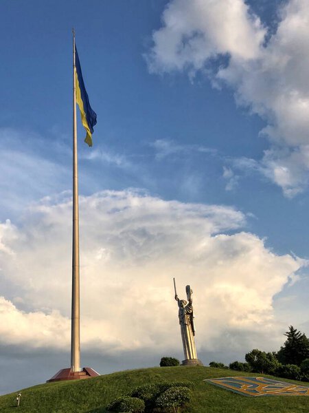 27.05.2023, Ukraine, Kyiv. Historical monument Motherland in Kyiv with a trident - a symbol of Ukraine. Ukrainian yellow-blue flag
