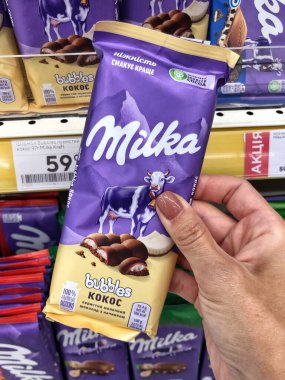 25.09.2023, Ukrayna, Harkiv, Milka çikolatası raflarda. Bir sürü mor Milka çikolatası. Milka, Mondelez International firması tarafından üretilen bir çikolata şekerlemesi.. 