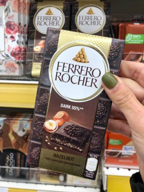 03.11.2023 Ukrayna, Harkov, Çikolatalı Ferrero Rocher ve Rafaello ellerinde. Marketin rafında nefis çikolata.