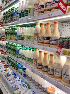 15.07.2023, Ukrayna, Harkov, mandıra ürünleri süpermarket zemininde: büyük bir şişe yoğurt seçimi