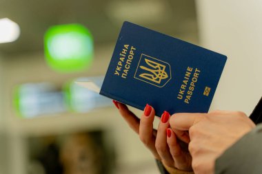 Ukrayna 'nın biyometrik pasaportu. Bir kadının eli pasaportta gezinir..