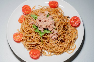 Cooking. Spaghetti with tuna and tomatoes.