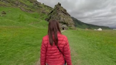 Kız pitoresk bir yolda yürüyor. İzlanda.
