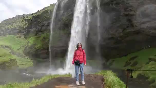 Das Mädchen Geht Vor Dem Hintergrund Eines Wasserfalls Island — Stockvideo