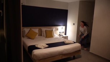 Bir kız otel yatağına atlıyor..