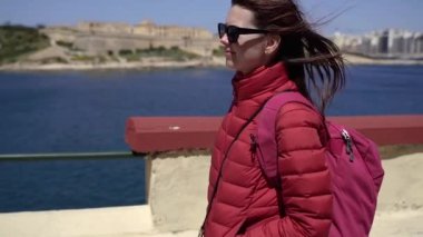 Bir kız eski şehrin arka planında yürür. Malta.