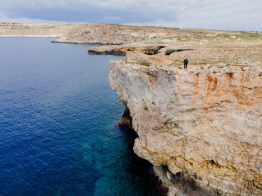 Malta. Yukarıdan bak. Bir turist uçurum boyunca yürür.