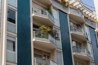 Çok katlı bir bina. Taze çiçekli güzel bir balkon cephesi.