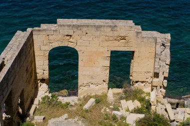 Terk edilmiş eski ev denizin arka planına karşı.
