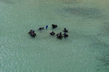 Dalıyoruz. Dalgıçlar suya. Genel plan.