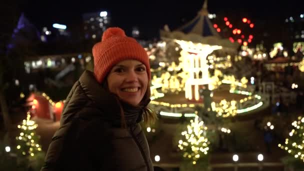 Parque Atracciones Navidad Una Mujer Saluda Delante Carrusel Giratorio — Vídeo de stock